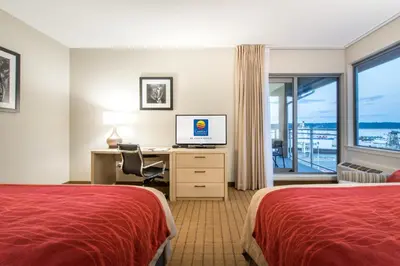 a hotel room with two beds and a desk with a computer at Comfort Inn & Suites in Campbell River