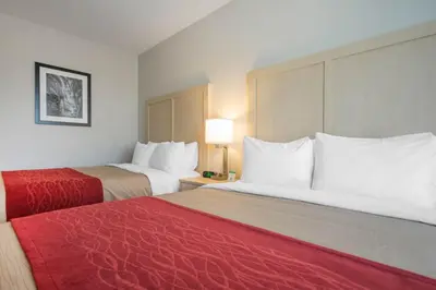 a hotel room with two beds with red sheets at Comfort Inn & Suites in Campbell River