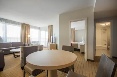 a hotel room with a table and a couch and a bed at Comfort Inn & Suites in Campbell River