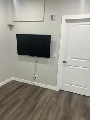 a flat screen tv hanging on a wall next to a door at Beautiful suite in Balzac