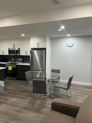 a kitchen with a table and chairs and a clock on the wall at Beautiful suite in Balzac