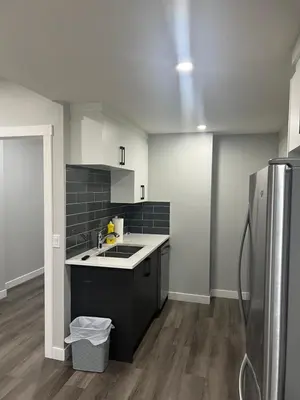 a kitchen with a sink and a refrigerator at Beautiful suite in Balzac