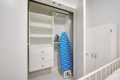 a walk in closet with a blue umbrella in it at Basement Suite In Vancouver in Vancouver