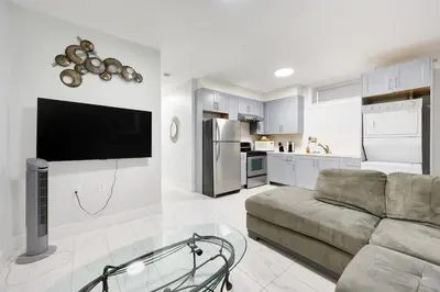 a living room with a couch and a kitchen at Basement Suite In Vancouver in Vancouver