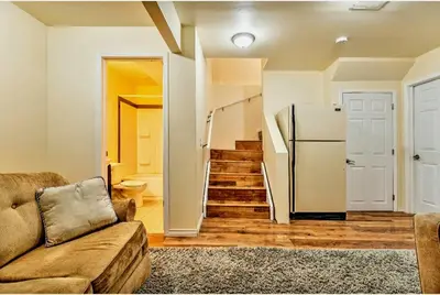 a living room with a couch and a refrigerator at Basement Apartment in Calgary