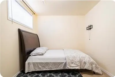 a bedroom with a bed in a room with a window at Basement Apartment in Calgary