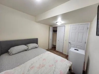 a bedroom with a bed and a white door at Basement Apartment in Calgary