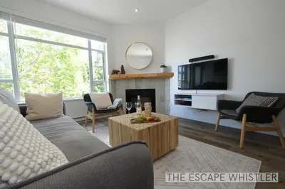 a living room with a couch and a fireplace at Whistler Village 2BR 2BA Top-Floor Condo with Hot Tub and Parking in Whistler