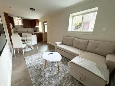 a living room with a couch and a table at Cozy 1BR Near Skytrain - Explore Vancouver Easily in Vancouver
