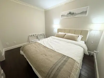 a bedroom with a bed with white sheets and pillows at Cozy 1BR Near Skytrain - Explore Vancouver Easily in Vancouver