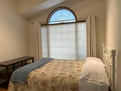 a bedroom with a bed in front of a window at Luxury bungalow in NW Calgary in Calgary