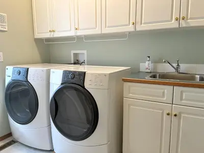 a kitchen with a washing machine and a sink at Luxury bungalow in NW Calgary in Calgary