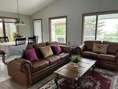 a living room with a brown couch and a table at Luxury bungalow in NW Calgary in Calgary