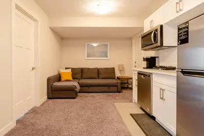 a living room with a couch and a kitchen at Exquisite One Bedroom Apartment in NW in Calgary