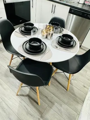 a white table with black chairs and plates on it at The Glacier Royale - 1 Bed Suite in NW Calgary in Calgary