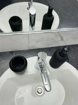 a bathroom sink with a faucet and a mirror at The Glacier Royale - 1 Bed Suite in NW Calgary in Calgary