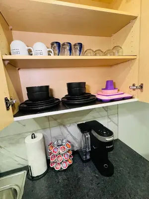 a kitchen counter with a coffee maker and cups at The Glacier Royale - 1 Bed Suite in NW Calgary in Calgary