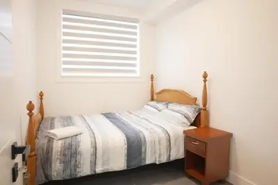 a bedroom with a bed and a window at New Luxury Walkout Suite Near University-BY ROOM in Calgary