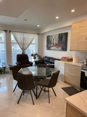 a kitchen and living room with a glass table and chairs at New Luxury Walkout Suite Near University-BY ROOM in Calgary
