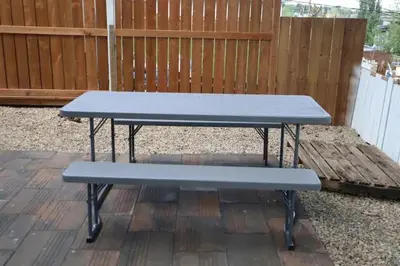 a blue picnic table sitting on a patio at Cute HighlandPark House in Calgary