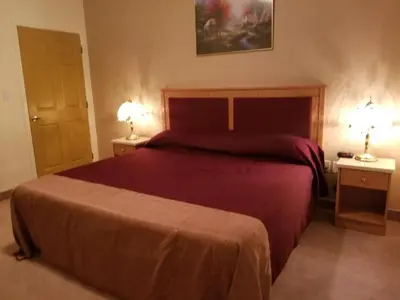 a bedroom with a large bed and two night stands at New Imperial Suites in Whitecourt