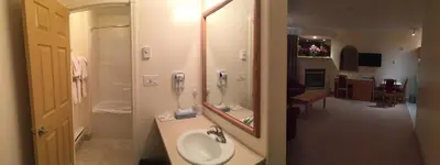 a bathroom with a sink and a mirror at New Imperial Suites in Whitecourt
