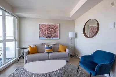 a living room with a couch and a chair at Stylish Modern Apartment In The Heart Of Old Town Victoria in Victoria
