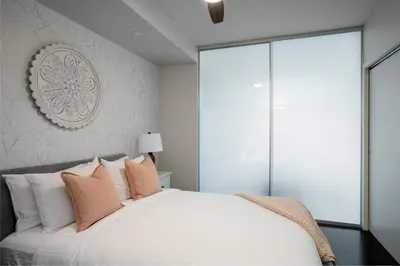 a bedroom with a white bed with pink pillows at Chic And Cozy Apartment In Old Town in Victoria
