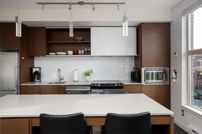 a kitchen with a white counter and wooden cabinets at Chic And Cozy Apartment In Old Town in Victoria