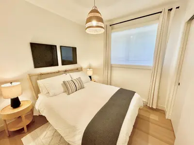 a bedroom with a large white bed and a window at Central Moodyville Retreat in North Vancouver