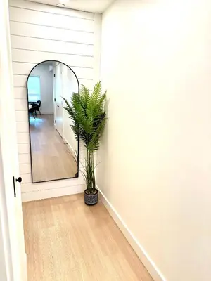 a hallway with a mirror and a potted plant at Central Moodyville Retreat in North Vancouver