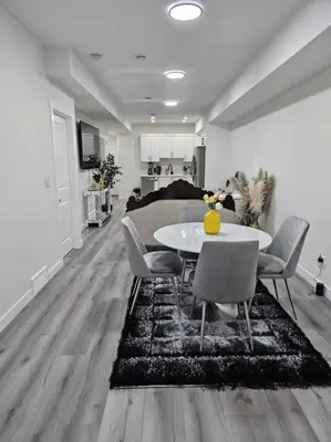 a dining room with a white table and chairs at Comfort Guest Suite NE Calgary - Near Airport in Calgary