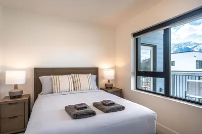 a bedroom with a bed and a large window at Mountain Revelation by Revelstoke Vacations in Revelstoke