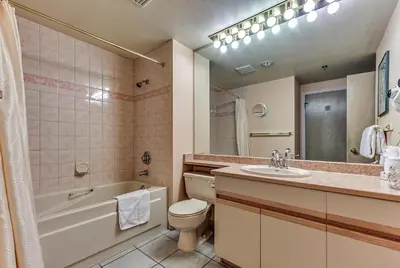 a bathroom with a sink and a toilet and a bath tub at Greystone Lodge 214 Ski-in Out in Whistler