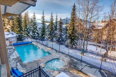 an indoor swimming pool in the snow on a balcony at Greystone Lodge 202 Ski-in Out in Whistler