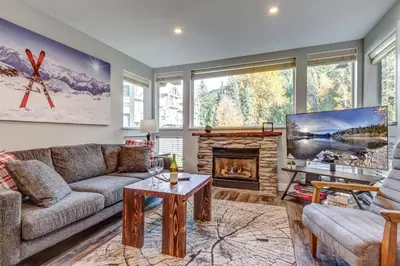 a living room with a couch and a fireplace at Greystone Lodge 329 Ski-in Out in Whistler