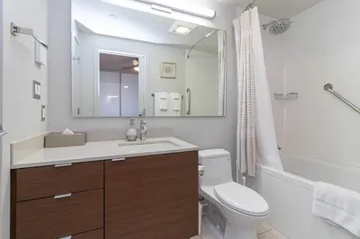 a bathroom with a sink and a toilet and a mirror at Chic And Cozy Condo In Old Town Victoria in Victoria