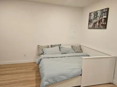 a white bedroom with a bed in a room at Brand new suite in langley close to everything in Langley