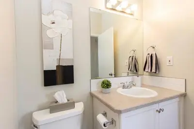 a bathroom with a sink and a toilet and a mirror at Spacious 3bedrm for family or business travellers in Red Deer