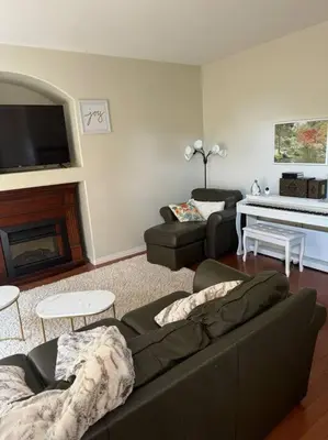 a living room with a couch and a piano at Spacious 3bedrm for family or business travellers in Red Deer
