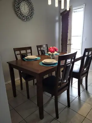 a wooden dining room table with chairs and a vase of flowers at Elegant 4-Bedroom Family Home Master in Calgary