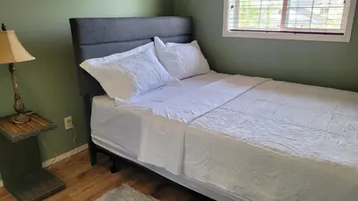 a bed with white sheets and pillows in a bedroom at Elegant 4-Bedroom Family Home Master in Calgary