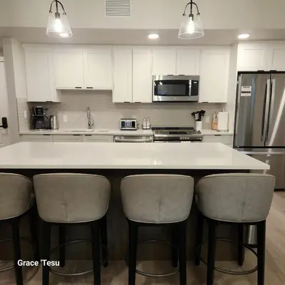 a kitchen with a white counter and some chairs at Cozy Cove Retreat Escape to Tranquility Stay in Simplicity in Dead Man's Flats