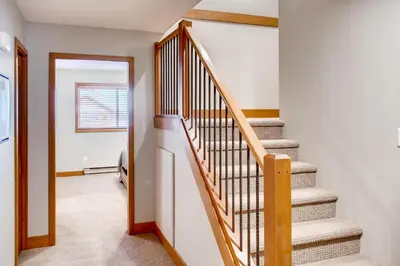 a staircase in a home with white walls at Moonshine Crescent 385 by Okanagan Premier in Big White