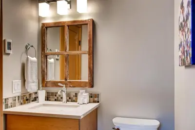 a bathroom with a sink and a mirror and a toilet at Moonshine Crescent 385 by Okanagan Premier in Big White