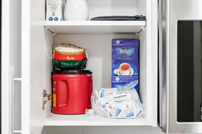 a refrigerator shelf with a red container and some food at Modern Studio Unit - Close to DT in Edmonton