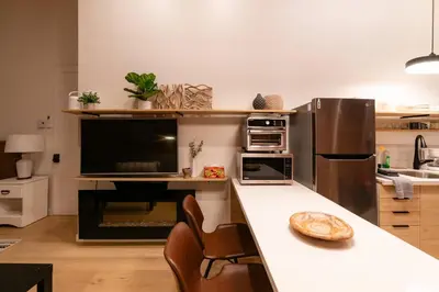 a kitchen with a counter with chairs and a refrigerator at Stylish downtown apartment in Grand Forks, BC in Grand Forks