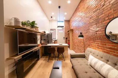 a living room with a couch and a brick wall at Stylish downtown apartment in Grand Forks, BC in Grand Forks