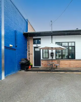 a table with an umbrella in front of a building at Stylish downtown apartment in Grand Forks, BC in Grand Forks