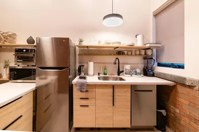 a kitchen with a stainless steel refrigerator and a sink at Stylish downtown apartment in Grand Forks, BC in Grand Forks